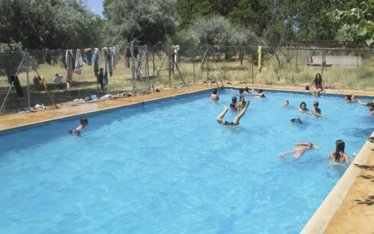 Piscina al aire libre con un grupo bañándose